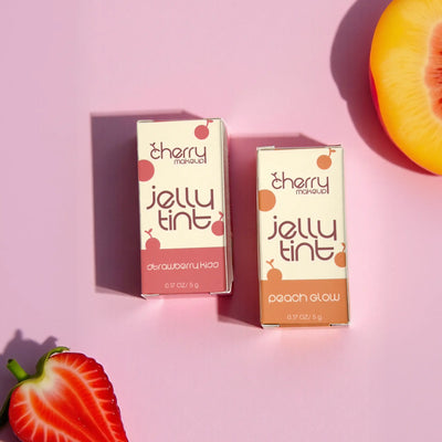 Two boxes of cherry makeup jelly tint on a pink background with fruits.
