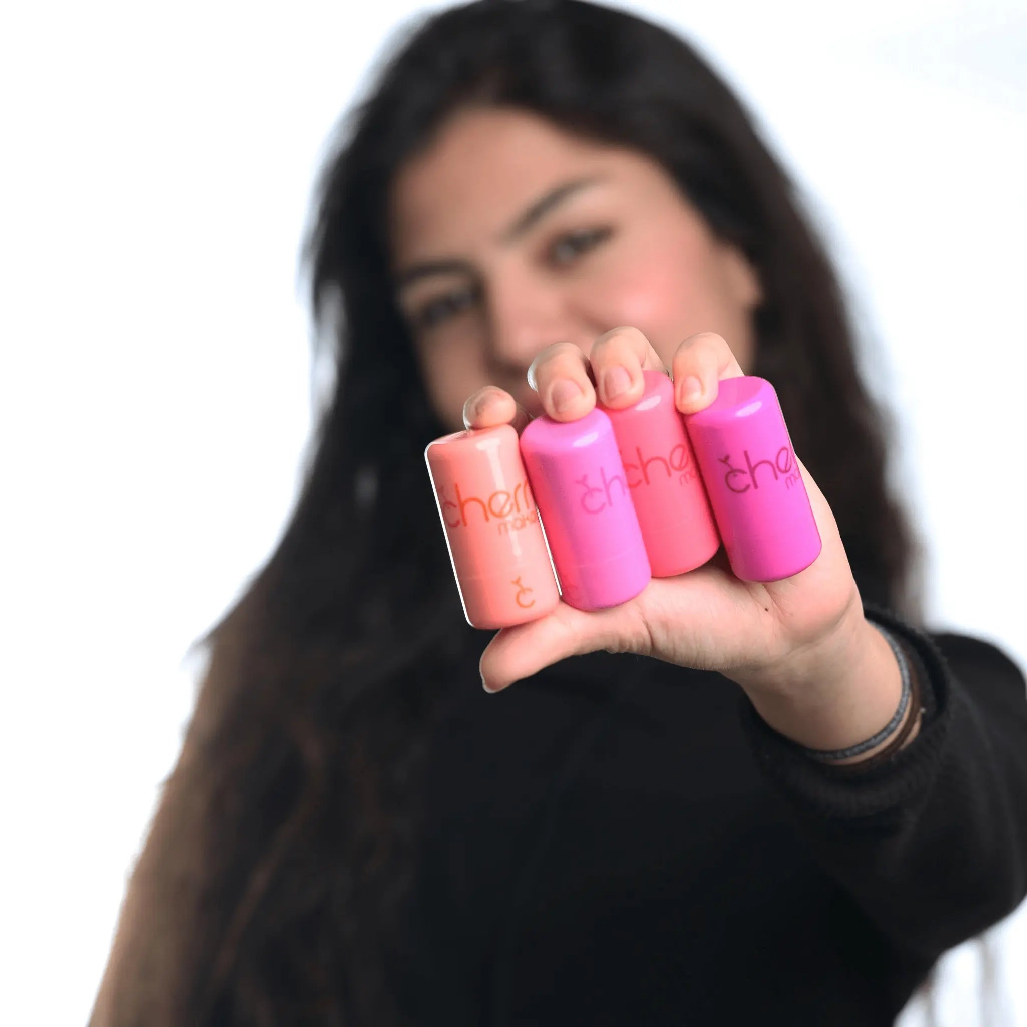 Model holding all Cherry Makeup Jelly Tint shades - Strawberry Kiss, Cherry Bomb, Peach Glow, and Berry Pop - Vegan, Hydrating Lip & Cheek Tints
