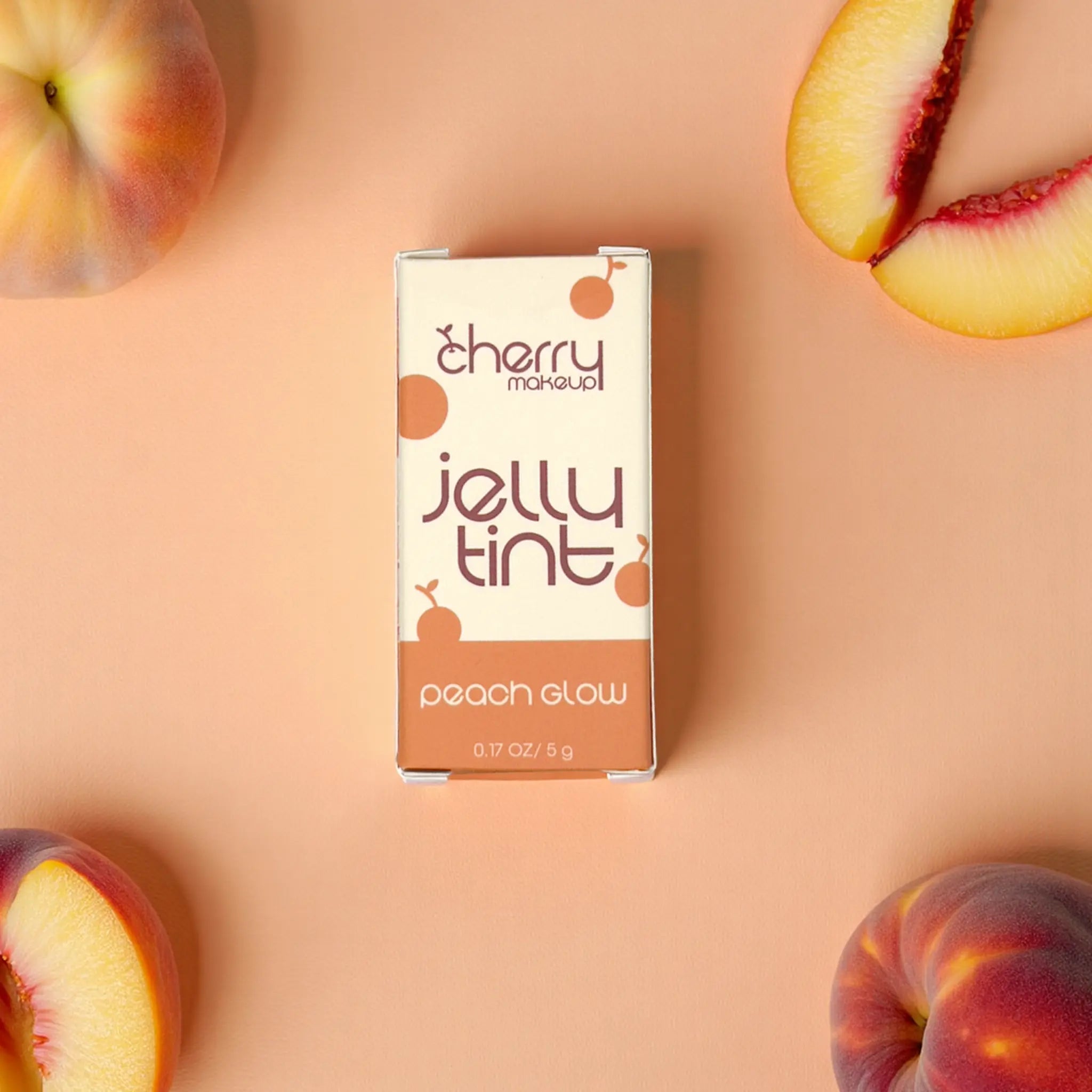 Cherry Makeup Jelly Tint packaging with peaches on a peach-colored background