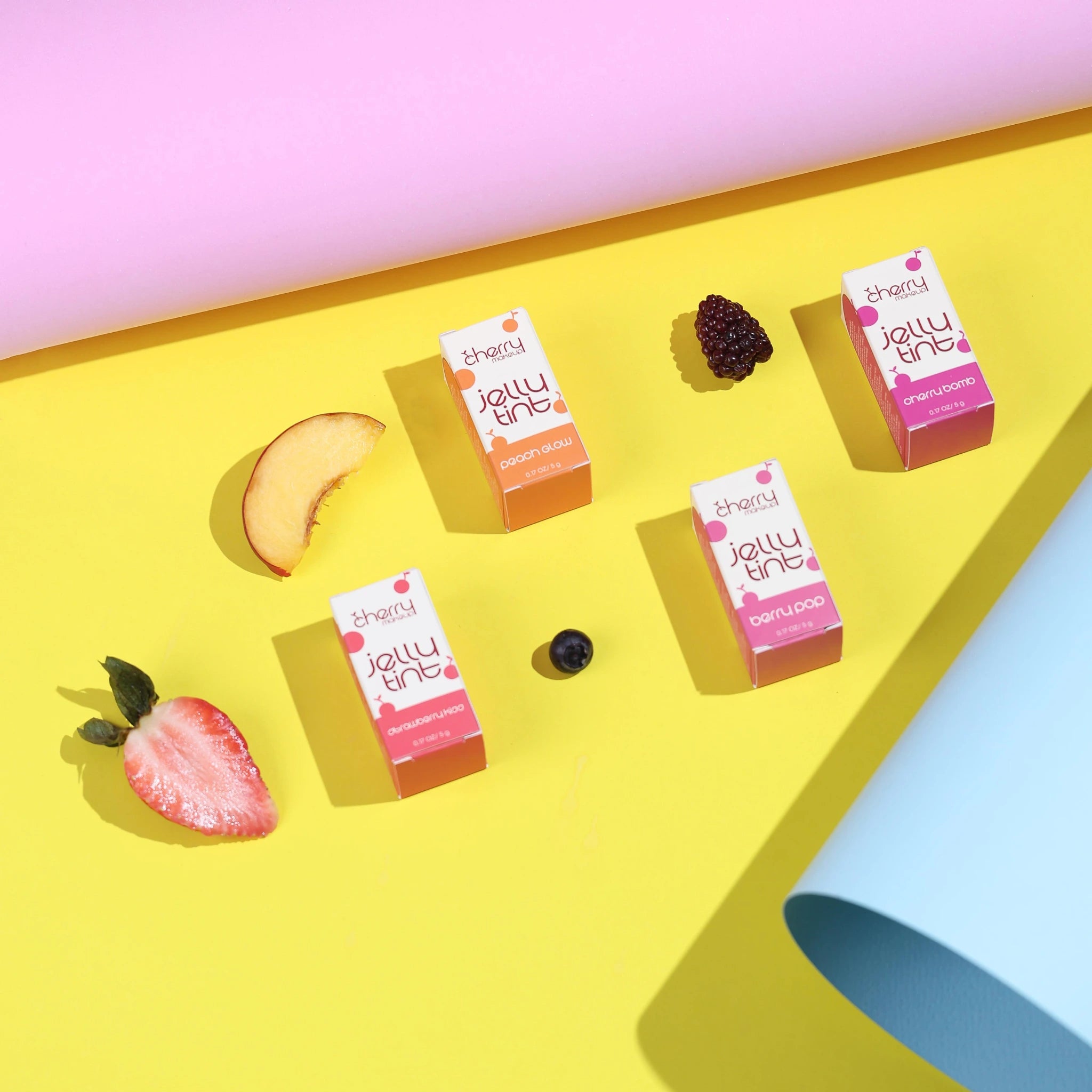 Jelly tine boxes on a yellow surface with fruit slices