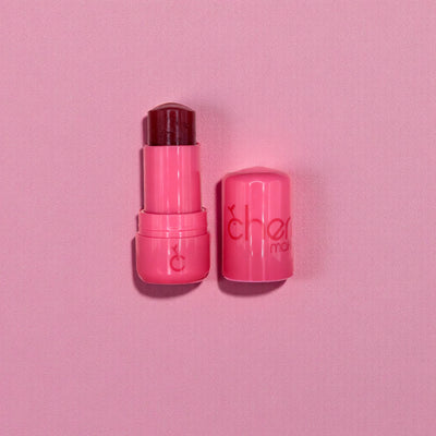 Pink lip balm with visible brand name on a pink background
